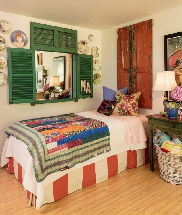 Hình ảnh phòng ngủ nhỏ với tường và trần màu trắng, sàn gỗ, ga gối màu sắc, đĩa trang trí, khung cửa đậm chất hoài cổ