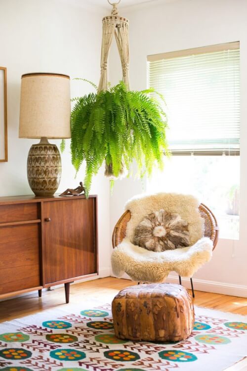 Hình ảnh góc đọc sách tại nhà với ghế mấy lót lông, thảm trải thổ cẩm, chậu cây dương xỉ treo