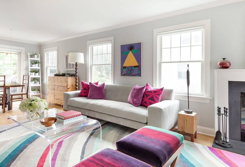 Hình ảnh phòng khách với gối tựa sofa, thảm trải, bọc đệm màu hồng, trắng, xanh lam kết hợp