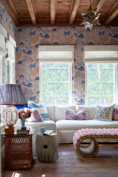 Hình ảnh một góc phòng khách với sofa trắng, cửa sổ kính lớn, giấy dán tường họa tiết trang nhã màu xanh da trời