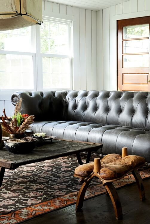 Hình ảnh một góc phòng khách ấn tượng với ghế sofa da lớn màu đen kiểu dáng cổ điển