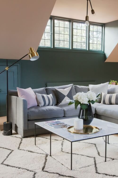Hình ảnh phòng khách với sofa màu trung tính, gối tựa đơn sắc, bàn trà kính, thảm trải  sang trọng