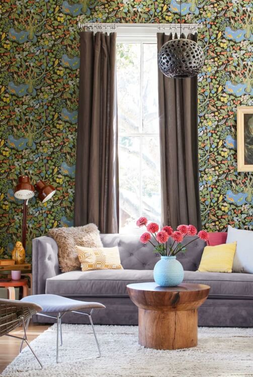 Hình ảnh một góc phòng khách nhỏ với rèm cửa màu nâu dài sát sàn nhà, giấy dán tường họa tiết bắt mắt