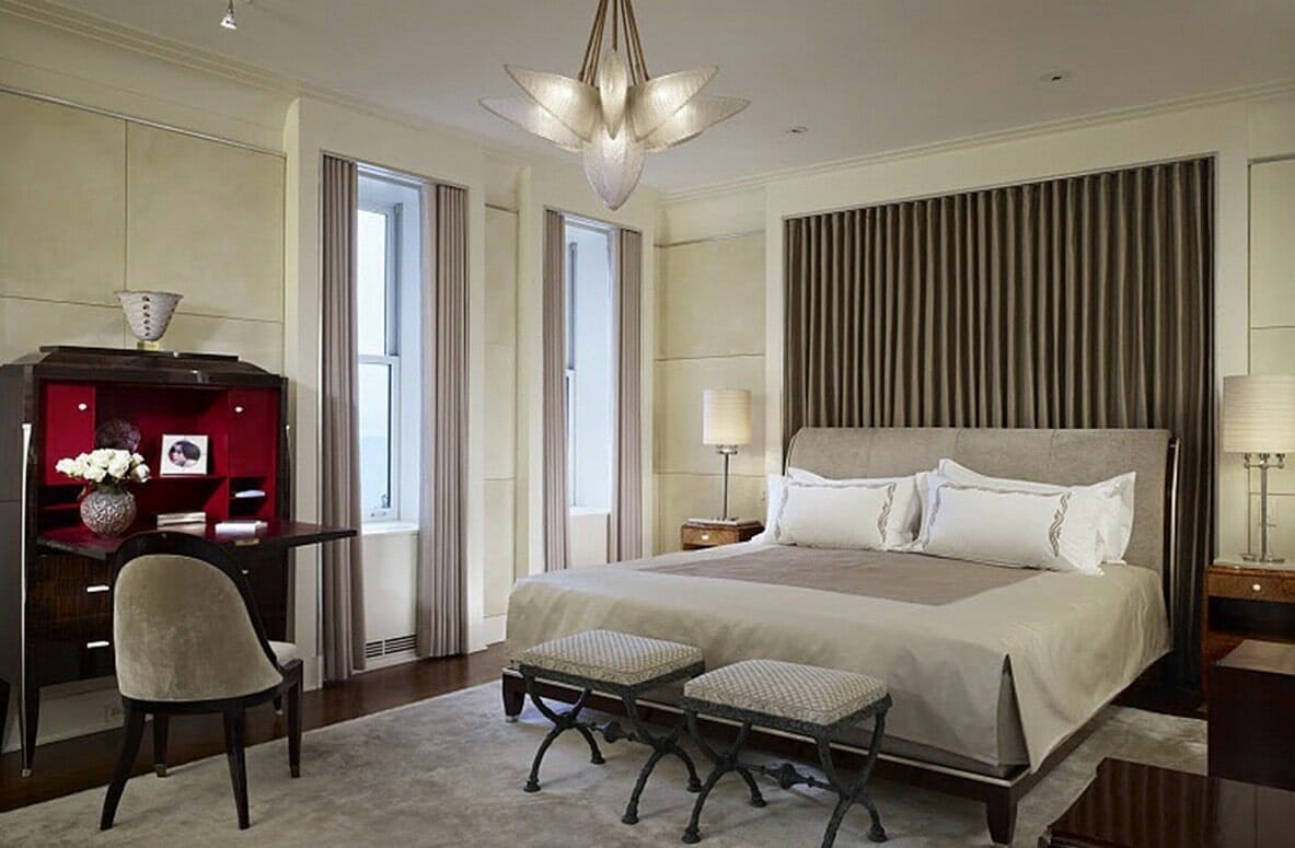 Hình ảnh phòng ngủ phong cách art deco với giường nệm êm ái, tường sơn màu be, trần màu trắng, bàn làm việc màu đỏ đô