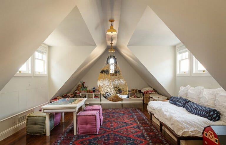 Hình ảnh phòng chơi gác mái kiêm phòng ngủ cho khách với thảm trải sàn họa tiết thổ cẩm, ghế xích đu, sofa giường êm ái, cửa sổ kính lớn