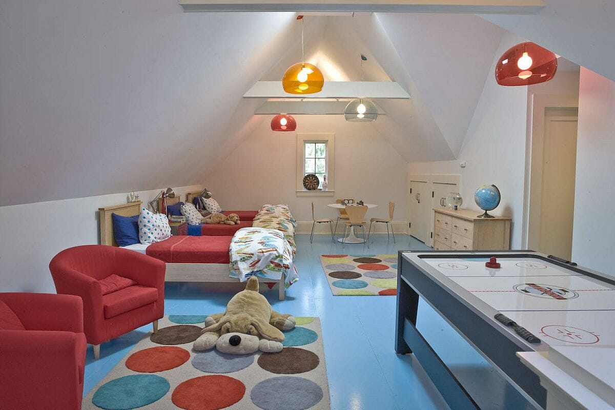 Hình ảnh phòng chơi trên tầng áp mái với sàn màu xanh dương, ghế ngồi đỏ đô, thảm chấm bi lớn, đèn trang trí