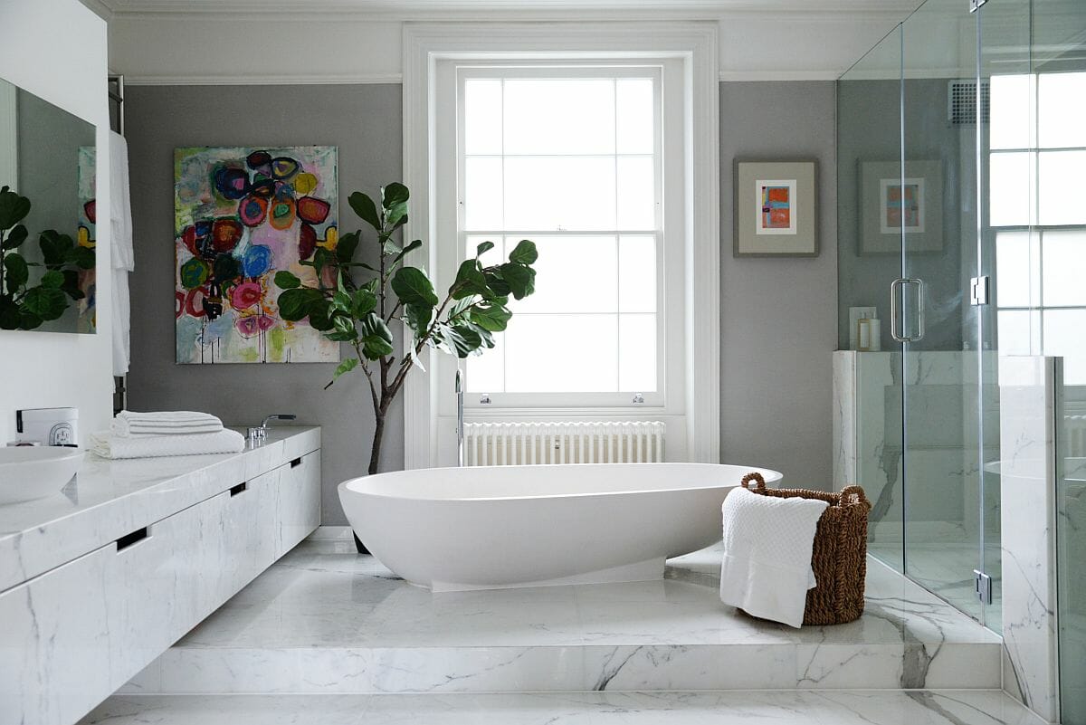 Hình ảnh phòng tắm mùa hè với tông màu xám - trắng kết hợp ăn ý, chậu cảnh lớn đặt cạnh bồn tắm, tranh treo tường màu sắc bắt mắt