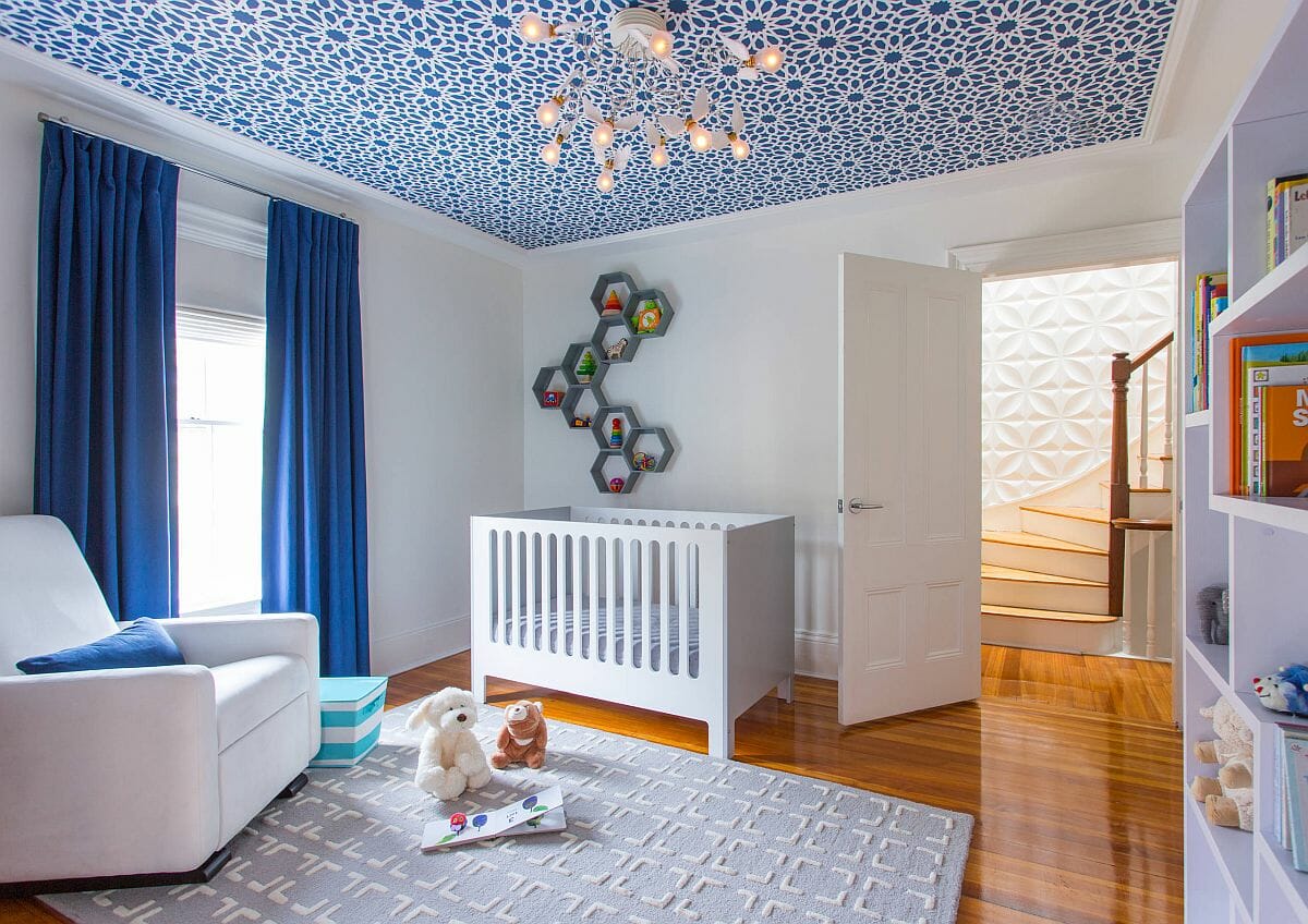 phòng ngủ của trẻ với rèm cửa xanh dương, kệ ong treo tường, giấy dán trần hoa văn đẹp
