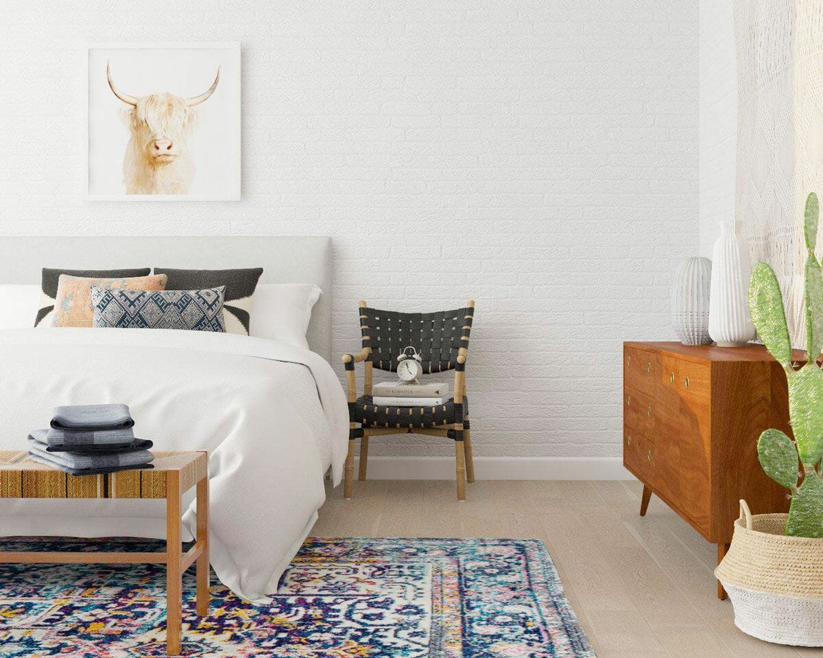 Hình ảnh một góc phòng ngủ hiện đại với ghế đầu giường, thảm trải họa tiết, tranh động vật, chậu cây xương rồng