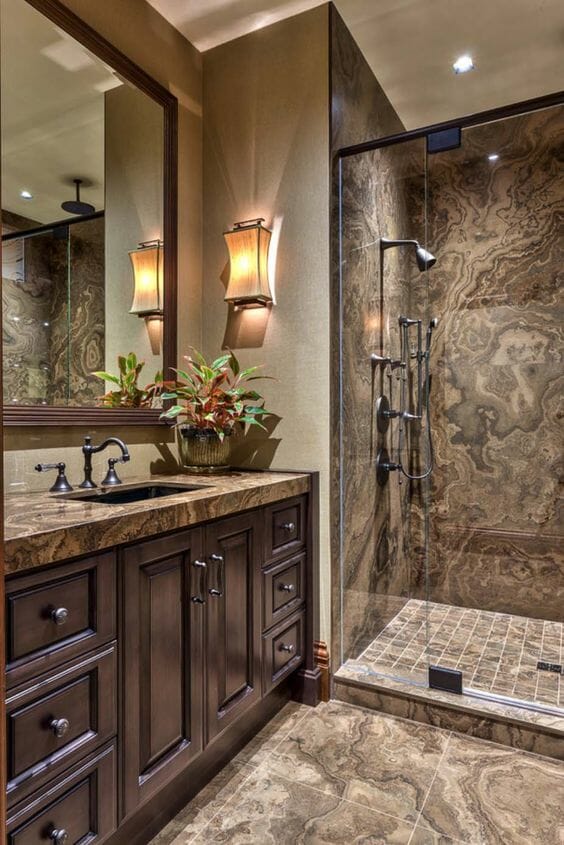 hình ảnh phòng tắm phong cách cổ điển với gạch ốp lát màu nâu, gương lớn gắn tường, đèn tường, chậu cây trang trí