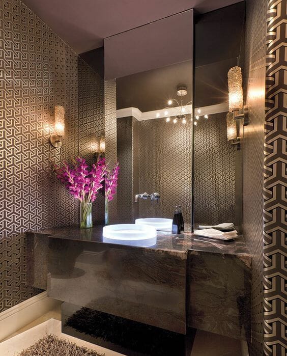 hình ảnh phòng tắm với trần màu nâu, giấy dán tường, bệ bồn rửa, thảm trải cùng màu nâu, gương lớn gắn tường, đèn độc đáo