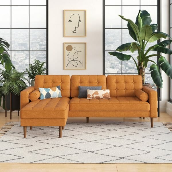 Mẫu ghế sofa khung gỗ kết hợp chất liệu bọc nệm giả da màu lạc đà đặt tển thảm màu trắng họa tiết kẻ sọc caro chéo