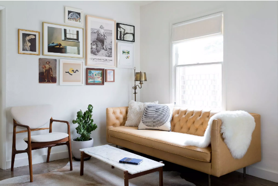 hình ảnh phòng khách với sofa màu vàng, tranh tường, cây xanh, cửa sổ kính