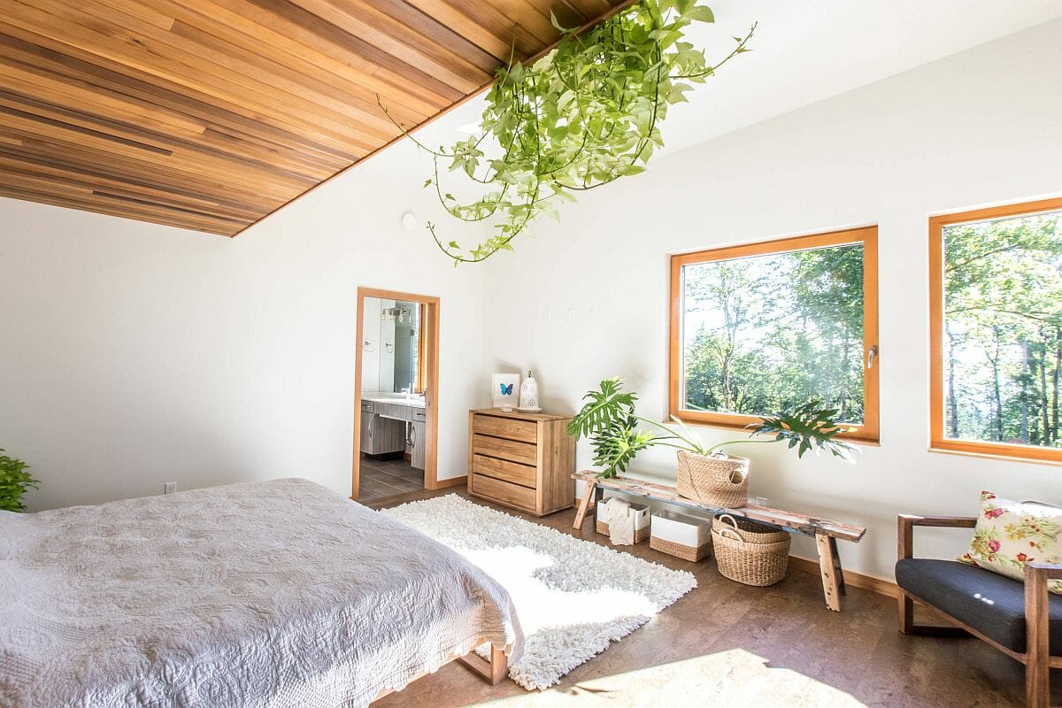 Hình ảnh phòng ngủ với trần gỗ, giá kệ gỗ, cửa sổ kính, cây xanh trang trí