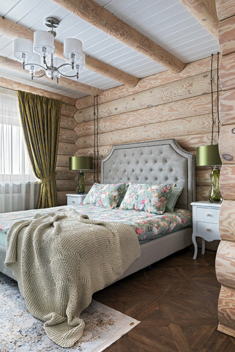 Hình ảnh phòng ngủ với dầm gỗ, tường đầu giường ốp gỗ, rèm cửa xanh lá, ga giường họa tiết hoa
