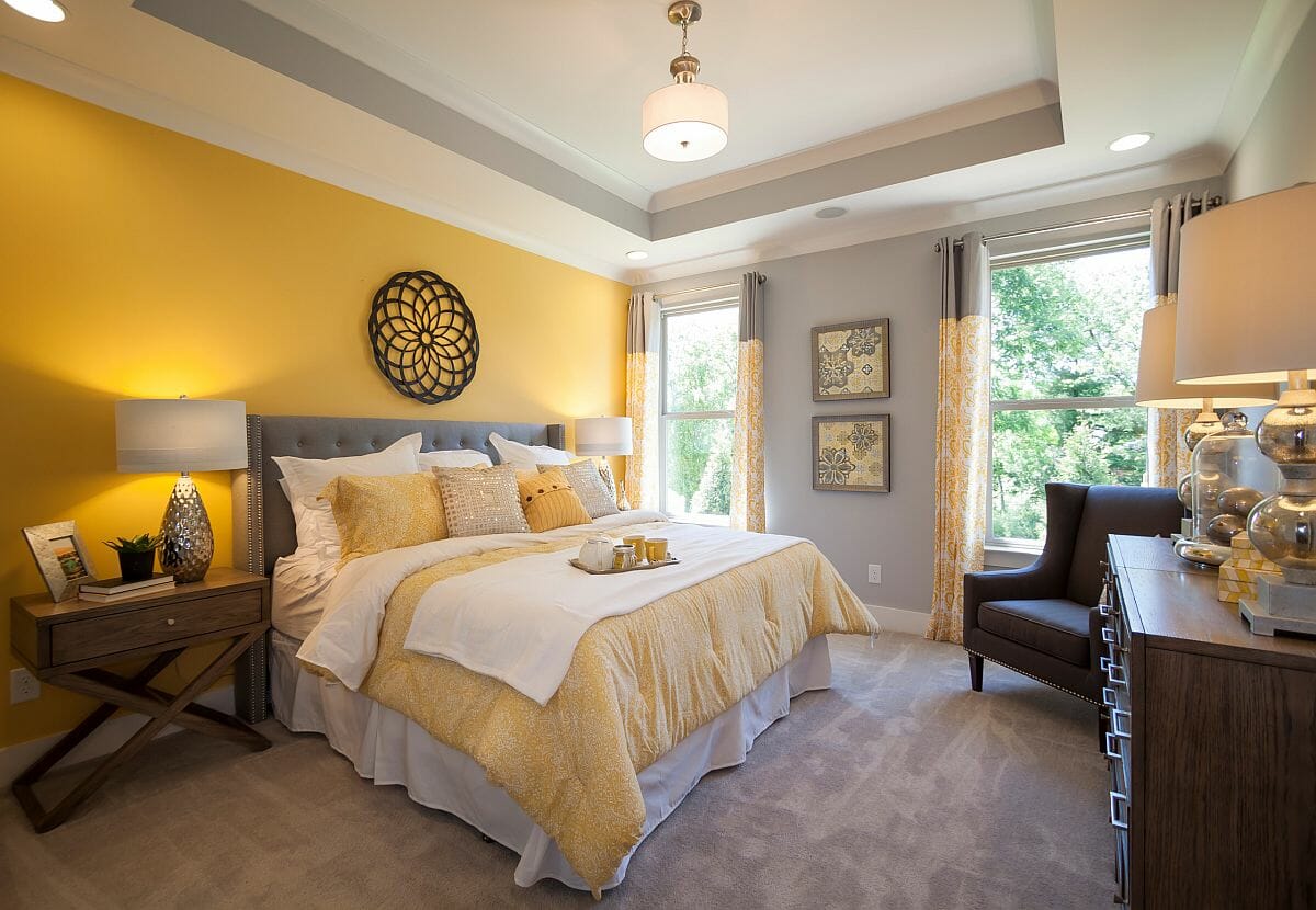 Hình ảnh phòng ngủ nổi bật với bức tường màu vàng tạo điểm nhấn đầu giường.