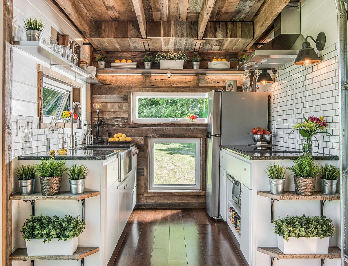 Hình ảnh phòng bếp với trần gỗ lộ thiên, các kệ lưu trữ đặt chậu cây thảo mộc xanh tốt