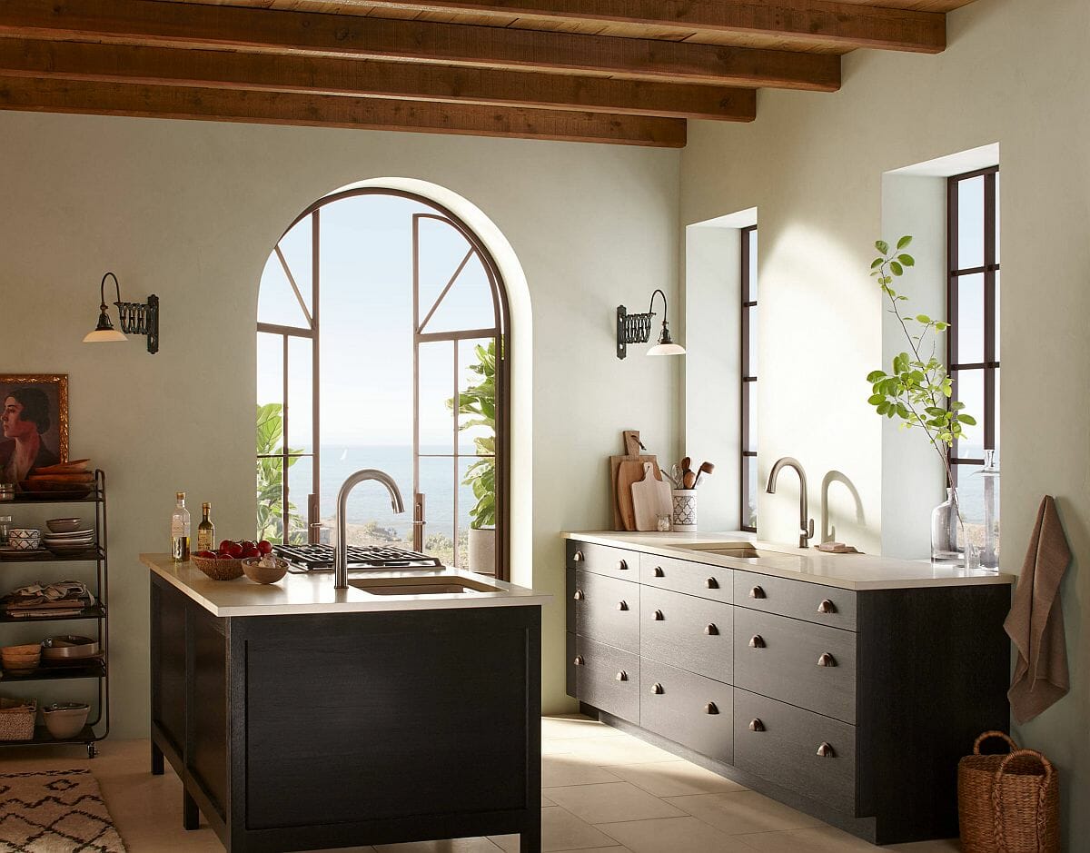 Hình ảnh phòng bếp với dầm gỗ lộ thiên, cửa sổ vòm mềm mại, đảo bếp màu đen