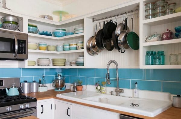 hình ảnh góc phòng bếp với hệ kệ mở gắn tường đựng bát đĩa, thanh treo xoong chảo