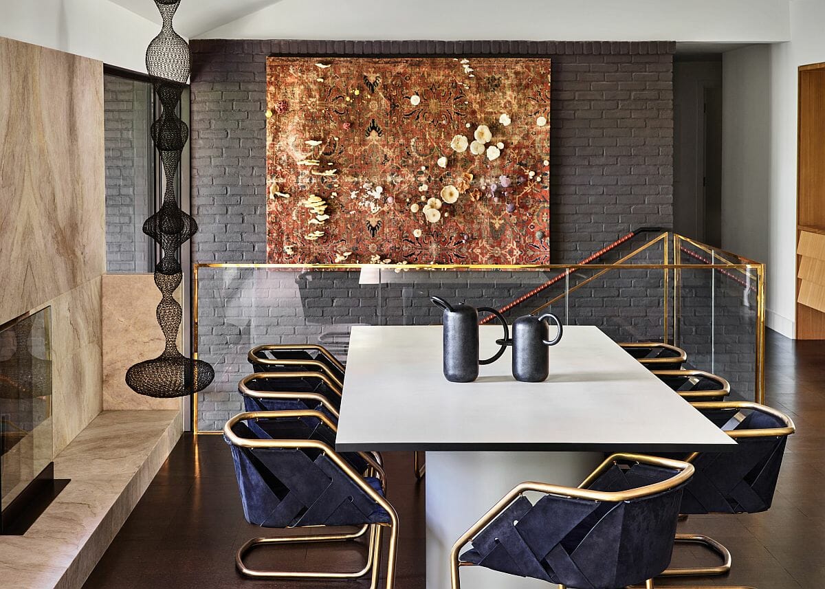 Phòng ăn phong cách hiện đại giữa thế kỷ tuyệt đẹp với nội thất khung kim loại vàng lấp lánh nổi bật trên phông nền màu xám trung tính.