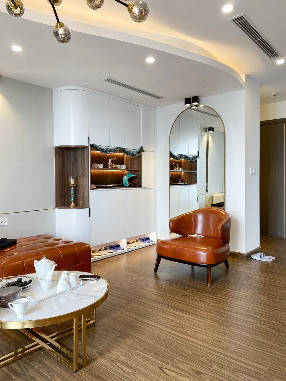 Lối vào căn hộ 150m2 với gương lớn và tủ kịch trần màu trắng